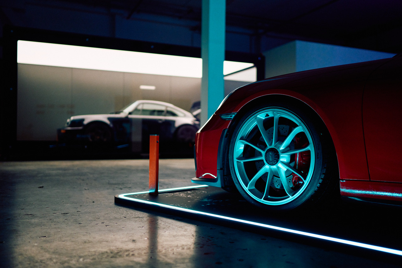 Red Porsche parked on an illuminated GuardPad platform in a showroom