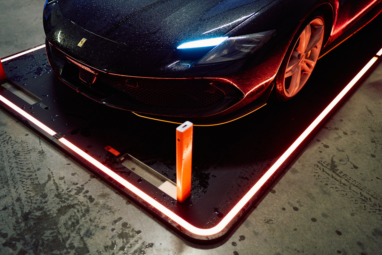 Supercar parked on an illuminated Fahrengold platform with the GuardPad bolt raised